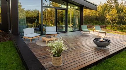 Modern outdoor living space with the contemporary Mix 850 fire pit creating warmth and atmosphere on a patio beside a glass-walled home